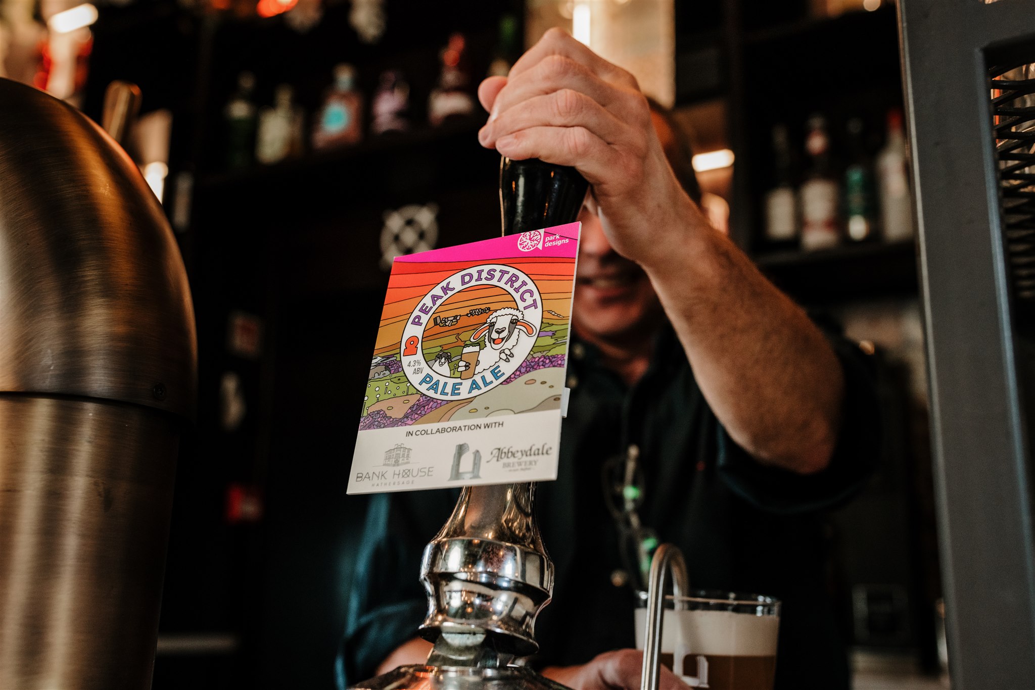 Team member pouring a pint of Peak District Pale Ale